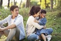 Asian family with one child relaxing in park Royalty Free Stock Photo