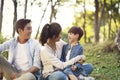 Asian family with one child relaxing in park Royalty Free Stock Photo