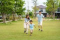 Asian family playing catch on yard or public park in neighborhood for daily health and well being, both physical and mental happy