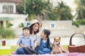 An Asian family plays with a Shiba Inu dog. Happy family with pet dog at picnic in a holiday