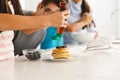 Asian family preparing breakfast in kitchen,father watching daughter put syrup on pancakes Royalty Free Stock Photo