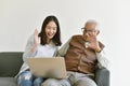 Asian family relationship, Daughter and elderly father using laptop computer talking to another.