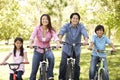 Asian family riding bikes in park Royalty Free Stock Photo