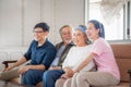 Asian family sitting on sofa and watching television in living room, Senior father mother and middle aged son and daughter, Royalty Free Stock Photo