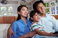 Asian Family Sitting On Sofa Watching TV Together Royalty Free Stock Photo