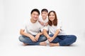 Asian family smiling and sitting together on floor isolated white background. Royalty Free Stock Photo