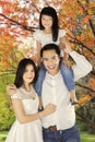 Asian family standing under autumn tree Royalty Free Stock Photo
