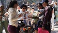 Asian family at a street fair crowded around a plate of fried chicken