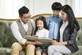 Asian family with two children reading book together Royalty Free Stock Photo