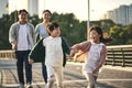 Asian family with two children taking a walk in city park Royalty Free Stock Photo