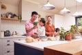 Asian Family Unpacking Local Food In Zero Waste Packaging From Bag In Kitchen At Home