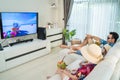 Asian Family watch TV screen, pretend on beach during summer in house. Happy Traveller people having fun stay at home, Parent Royalty Free Stock Photo