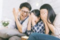 Asian family watching scary movies at home. Royalty Free Stock Photo