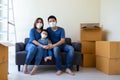 Asian family wearing protective medical mask for prevent virus covid-19 during moving day and relocating at new home.