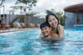 Asian Family, Young Boy Son and 40s Women Mother Having a Good Time Playing and Enjoying in Swimming Pool Royalty Free Stock Photo