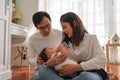 Asian family of young father and mother feeding a baby boy from milk bottle Royalty Free Stock Photo