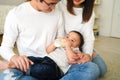 Asian family of young father and mother feeding a baby boy from milk bottle Royalty Free Stock Photo