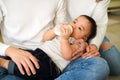 Asian family of young father and mother feeding a baby boy from milk bottle Royalty Free Stock Photo