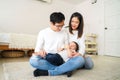 Asian family of young father and mother feeding a baby boy from milk bottle