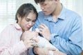 Asian family young father and mother feeding milk baby boy at home. Portrait of asian young couple father mother holding new born Royalty Free Stock Photo