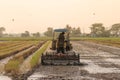 Asian farmer driving tractor car to prepare land for the new crop of rice, agriculture concept Royalty Free Stock Photo