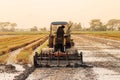 Asian farmer driving tractor car to prepare land for the new crop of rice, agriculture concept Royalty Free Stock Photo