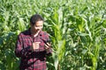 Asian farmer using smartphone in corn field Royalty Free Stock Photo