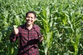 Asian farmer using smartphone in corn field Royalty Free Stock Photo