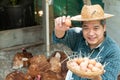 Asian farmers hold an eggs basket with their left hand and their right hand holding egg and holding up. At a chicken farm in their Royalty Free Stock Photo