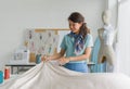 The Asian fashion designer admires her handiwork in meticulous preparation among colorful fabrics in her creative paradise