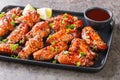 Asian fast food baked chicken wings in hoisin sauce with sesame seeds, served with green onion and lime close-up on a plate. Royalty Free Stock Photo