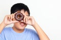 Asian fat boy holds a chocolate-coated donut He enjoys eating. Royalty Free Stock Photo