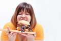 Asian fat woman eats a large hamburger