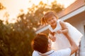 Asian father carrying his daughter up in the air and playing together in the park Royalty Free Stock Photo