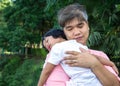 An Asian father is carrying a lovely daughter to her chest and the daughter is lying in the father chest. Asia family and love con Royalty Free Stock Photo