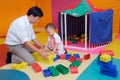 Asian father & cute little 1 year old toddler baby boy child having fun playing with big colorful plastic building blo Royalty Free Stock Photo