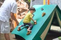 Asian Father and 2 - 3 years old toddler child having fun trying to climb on artificial boulders at playground, Little boy Royalty Free Stock Photo