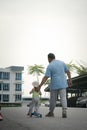 Asian father and daughter walking  and playing on the road at the day time. People having fun outdoors. Concept of friendly family Royalty Free Stock Photo