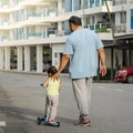 Asian father and daughter walking  and playing on the road at the day time. People having fun outdoors. Concept of friendly family Royalty Free Stock Photo
