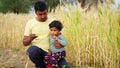 Asian father drinking a glass of Citrus fruit and Juice to his son. Man giving the energy source of citrus his toddler kid Royalty Free Stock Photo