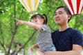 Asian Father embrace hug daughter dad love girl child play have fun in a park outdoor summer day family activity happy childhood Royalty Free Stock Photo