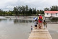 Asian Father Holding Children`s Hands Walking Above Boardwalk