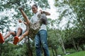 Asian father lift up two daughter to swing both