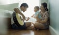 Asian father playing guitar with his boy and mother Royalty Free Stock Photo