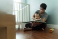 Asian Father reading book to his little cute baby son Royalty Free Stock Photo