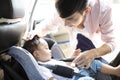 Father securing baby in the car seat