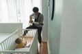 Asian Father singing and playing acoustic guitar while little Cute baby boy son sitting in the crib Royalty Free Stock Photo