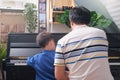 Asian Father and son playing piano at home, Children and Music