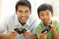 Asian father and son playing videogames