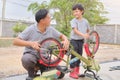 Asian Father and son spend time together, playing and repairing bicycle wheel, fixing bike Royalty Free Stock Photo